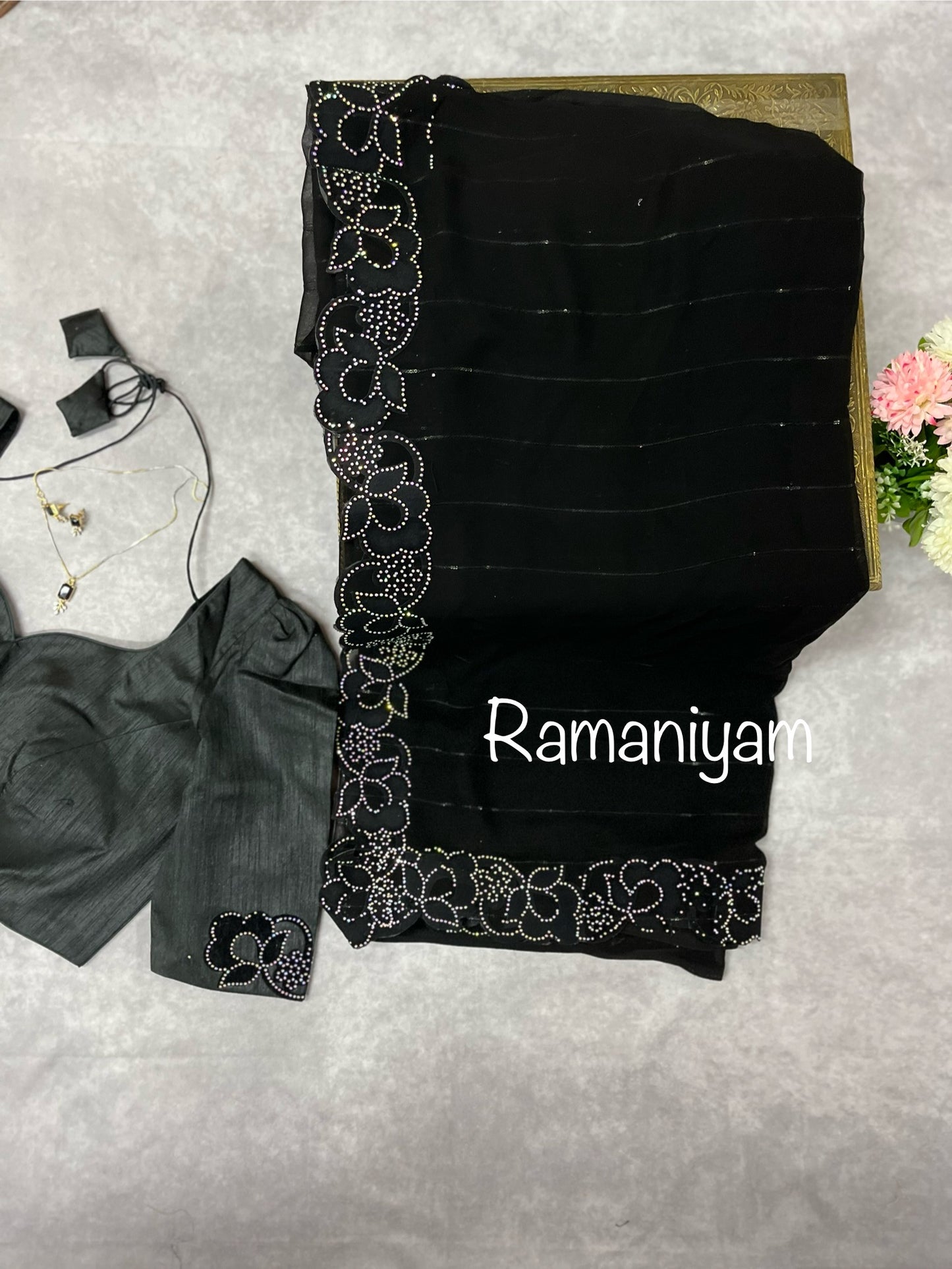 Party wear Black georgette saree featuring a beautiful cutwork border with crystal finishing